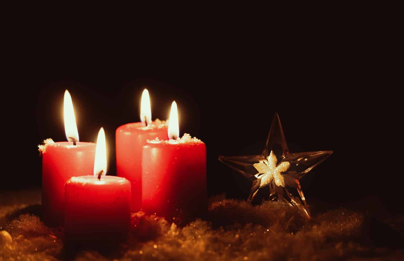 a group of red candles sitting next to a star